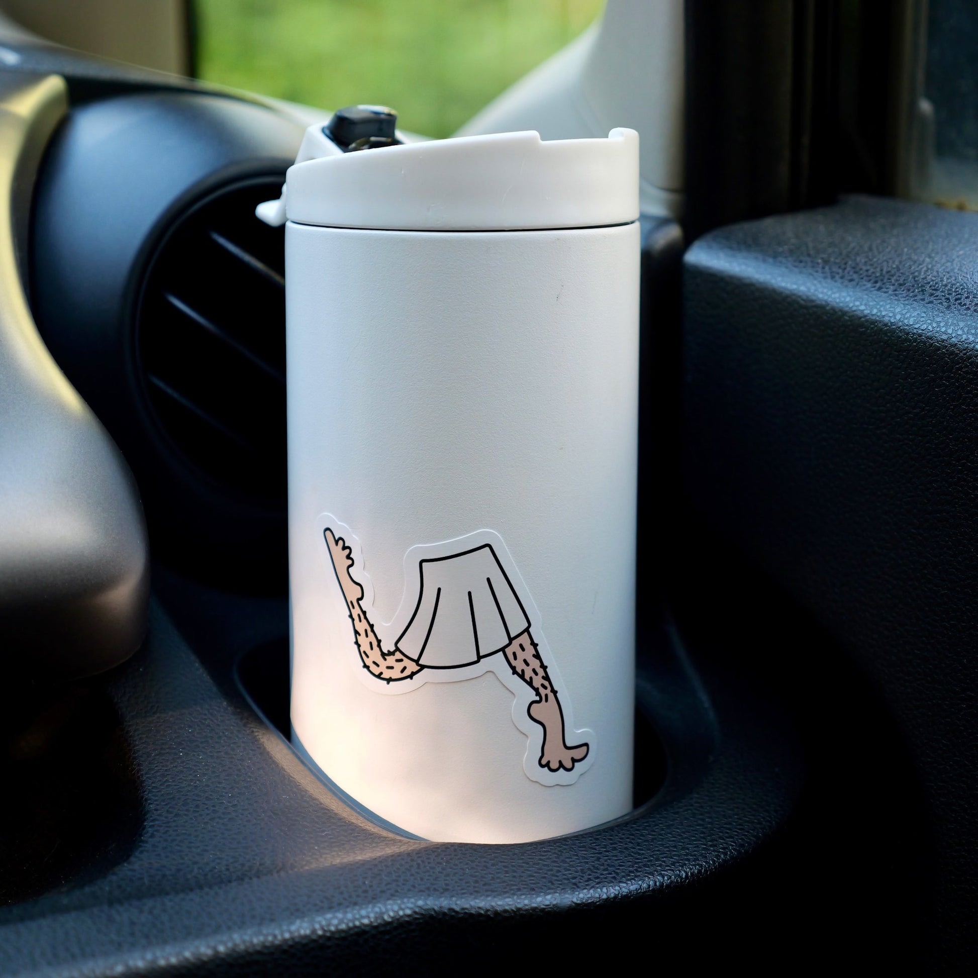 White to-go mug with a skirt + legs sticker, in a card cup holder.